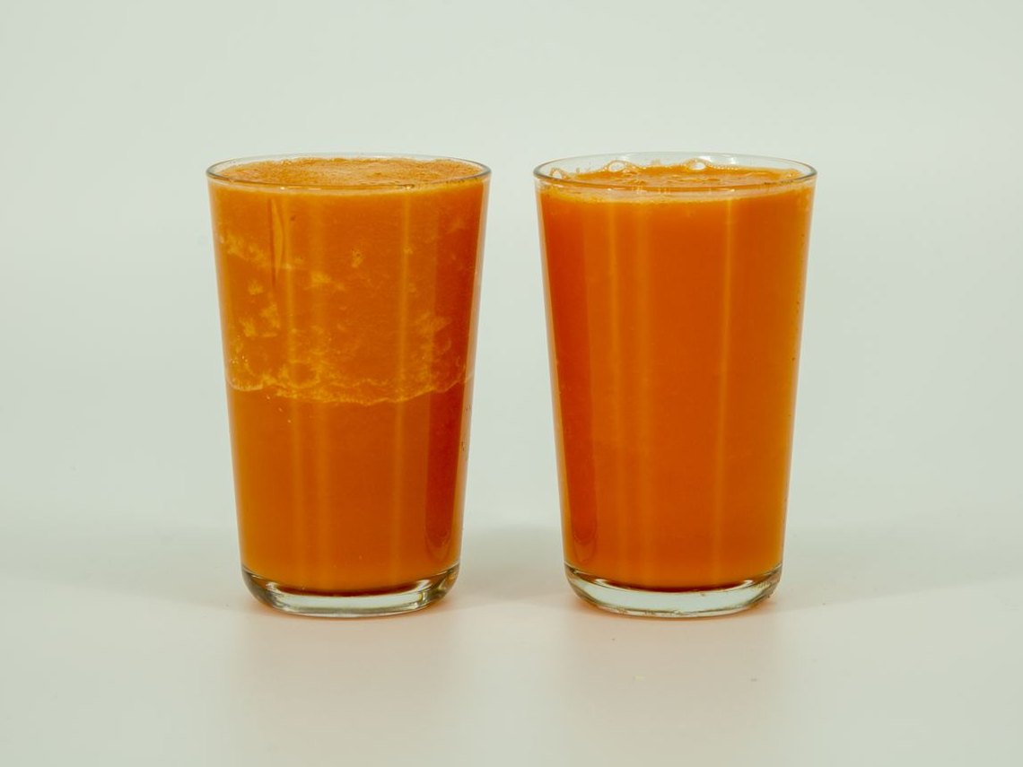 Two glasses of carrot smoothie 20 minutes after pouring. The vacuum-off glass on the left has separated; the vacuum-on glass on the right is still even.